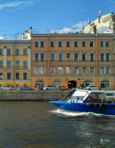 a blue boat in the water in front of a building at STN Apartments Budget in Saint Petersburg