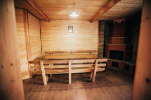 ein Holzzimmer mit einer Bank und einem Kamin in der Unterkunft Гостинний двір Гуцулка in Scheschory