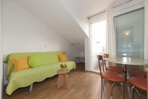 a living room with a green couch and a table at Apartments Milana 2 in Tučepi