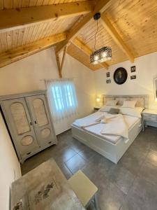 a bedroom with two beds and a wooden ceiling at Ibolya Apartman in Csisztapuszta