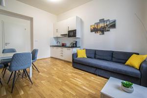 uma sala de estar com um sofá azul e uma cozinha em Stylish apartment in Prague best gastronomic area em Praga