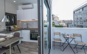 cocina con balcón con mesa y sillas en Spot Apart, en Atenas