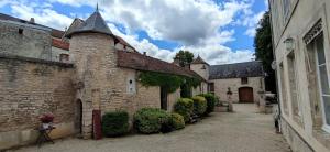 un callejón en un antiguo edificio de piedra con una torreta en Manoir de L'Echauguette, en Laignes