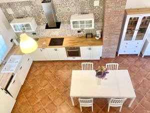 a kitchen with a white table and chairs at Bio Resort Mediterráneo in San Martín Sarroca