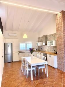 cocina con mesa blanca y sillas en Bio Resort Mediterráneo, en Sant Martí Sarroca