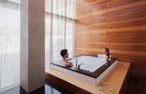 two people sitting in a bath tub in a room at Bluesun Hotel Elaphusa in Bol +66 photos