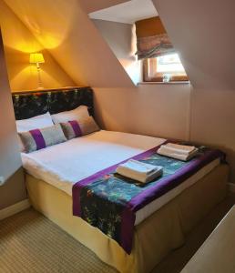 um pequeno quarto com uma cama num sótão em CASA GRINDA em Sibiu