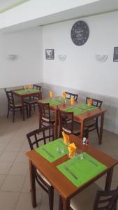 un comedor con mesas de madera y servilletas verdes en HOTEL RESTAURANT Bar LA KAHINA, en Chouzé-sur-Loire