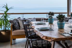 a wooden table with glasses and plants on a couch at Rigas Boutique Hotel & Spa in Afitos