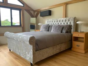 una camera da letto con un grande letto con una grande testiera di Little Oak Lodge a Hailsham