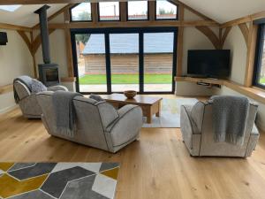 a living room with two couches and a flat screen tv at Little Oak Lodge in Hailsham
