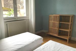 a room with two beds and a window and a book shelf at La Maison Blatin - 2 chambres & parking in Clermont-Ferrand +11 photos