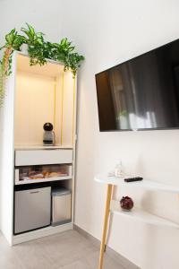 une pièce avec une table et une télévision sur un mur dans l'établissement Arechi Room, à Salerne