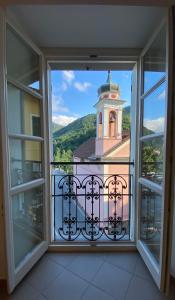 una ventana con vistas a una torre del reloj en Ostello Voltaggio en Voltaggio