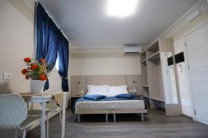 a bedroom with a bed and a table with a vase at HOME HOTEL in Castelfranco Veneto