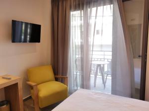 a room with a bed and a chair and a window at Liberty of Nafplio in Nafplio