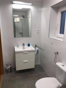 a white bathroom with a toilet and a sink at Rózsa Porta in Vonyarcvashegy