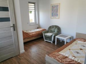 um quarto com uma cama, uma cadeira e uma janela em Reda apartments em Lublin