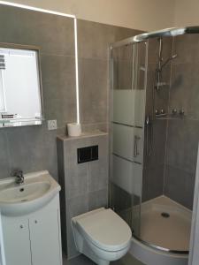 La salle de bains est pourvue d'une douche, de toilettes et d'un lavabo. dans l'établissement Reda apartments, à Lublin