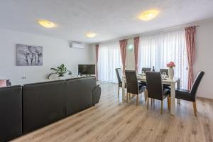 een woonkamer met een eettafel en stoelen bij Apartments Rogić in Crikvenica