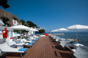 a row of lounge chairs and umbrellas on a pier at FURANO BAHARI in Agropoli