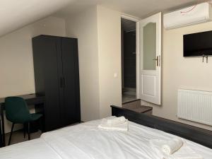 una camera con letto, sedia e televisore di Boutique Rooms with Parking a Oradea