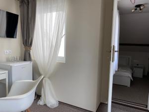 奥拉迪亚Boutique Rooms with Parking的通往卧室的大门,卧室配有白色窗帘