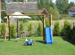 a playground with an umbrella and a toy car in a yard at Apartamenty na Wydmie in Gąski