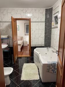 a bathroom with a bath tub and a sink at Apartment Adriana in Opatija