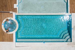 an overhead view of a swimming pool with a diver at Rigas Boutique Hotel & Spa in Afitos