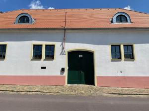 - un bâtiment blanc avec une porte et des fenêtres vertes dans l'établissement Bezauberndes Gästehaus in Satov, à Šatov