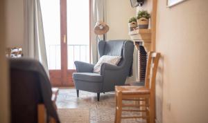 sala de estar con silla azul y ventana en Cal Giral I, en Cornudella