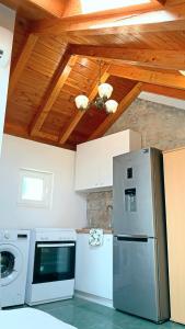 a kitchen with a refrigerator and a washer at Laura Studio Apartman in Mlini