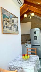 a kitchen with a table with a bowl of fruit on it at Laura Studio Apartman in Mlini