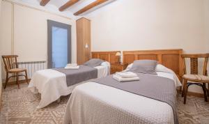 a room with two beds and a table and chairs at Cal Giral I in Cornudella