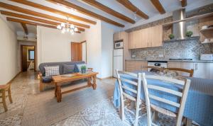 a kitchen and living room with a table and a couch at Cal Giral I in Cornudella