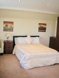 ein Schlafzimmer mit einem großen weißen Bett mit zwei Nachttischen in der Unterkunft 24 Elmhurst Road in Lytham St Annes