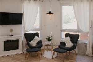 a living room with two chairs and a tv at Akro Studio apartman in Tuzla
