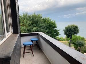 a balcony with two stools and a view of the ocean at Fos and Flame in Sozopol