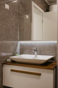 a bathroom with a sink and a mirror at Akro Studio apartman in Tuzla
