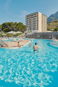 a group of people swimming in a swimming pool at Bluesun hotel Neptun - All inclusive in Tučepi