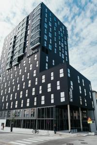 un grande edificio nero con una persona che lo sta di fronte di Comfort Hotel Bodø a Bodø