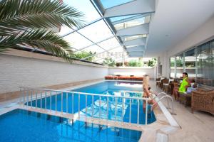 einen Pool in einem Haus mit Glasdecke in der Unterkunft Xperia Grand Bali Hotel - All Inclusive in Alanya