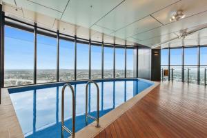 a large swimming pool in a building with windows at KOZYGURU SKYTOWER BRISBANE CBD 2 BED APT QBN222-1815 in Brisbane