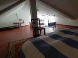 a bedroom with a bed and chairs in a room at Cozy Country House near Beaches in Azoia