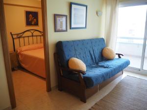 a bedroom with a blue chair and a bed at Apartament a 2 minuts de la platja, amb AC in Platja  d'Aro