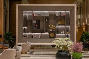 a lobby with a table and chairs in a building at Gardino Hotel & Residence in Riyadh