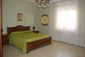 una camera con letto, finestra e lampadario a braccio di Gallipoli Apartment ActiveLife a Gallipoli