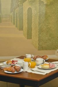 una mesa con platos de comida y tazas de café en Zanhotel Tre Vecchi en Bolonia