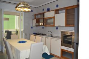una cucina con tavolo e tovaglia bianca di Gallipoli Apartment ActiveLife a Gallipoli Altre 32 foto